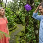 A man and woman reconnecting in a lush Hawaiian botanical garden, highlighting a silver compass pendant and a purple orchid.